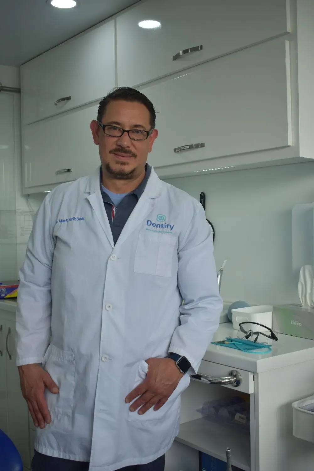 Male medical specialist in a white coat at his clinic